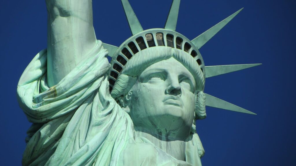 Detailed close-up of the Statue of Liberty against a clear blue sky.